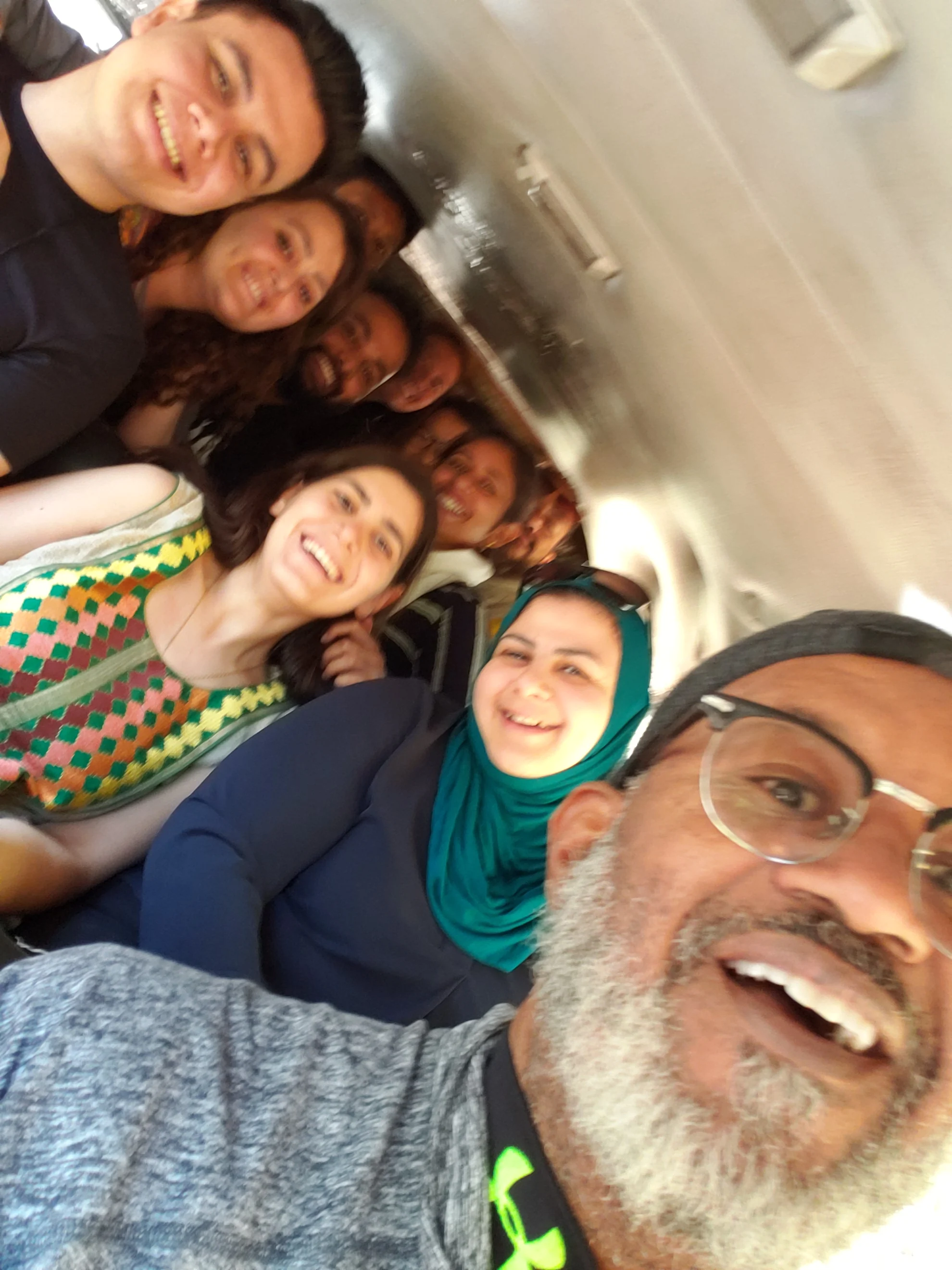 David and a group leaning together into a candid photograph, with the group visible.