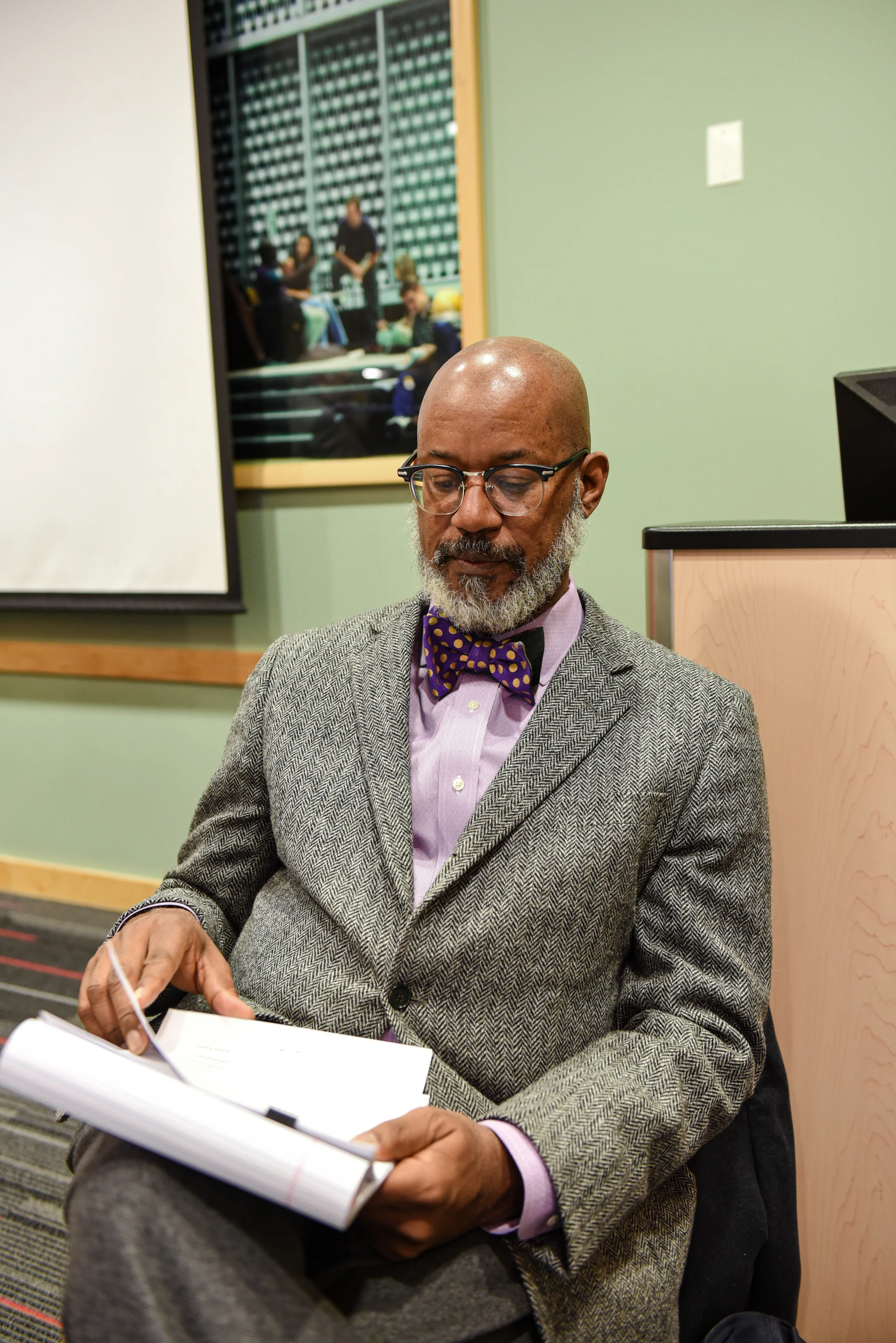 David seated, reading and working with papers