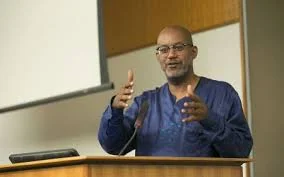 David seated at a table, speaking into a microphone.
