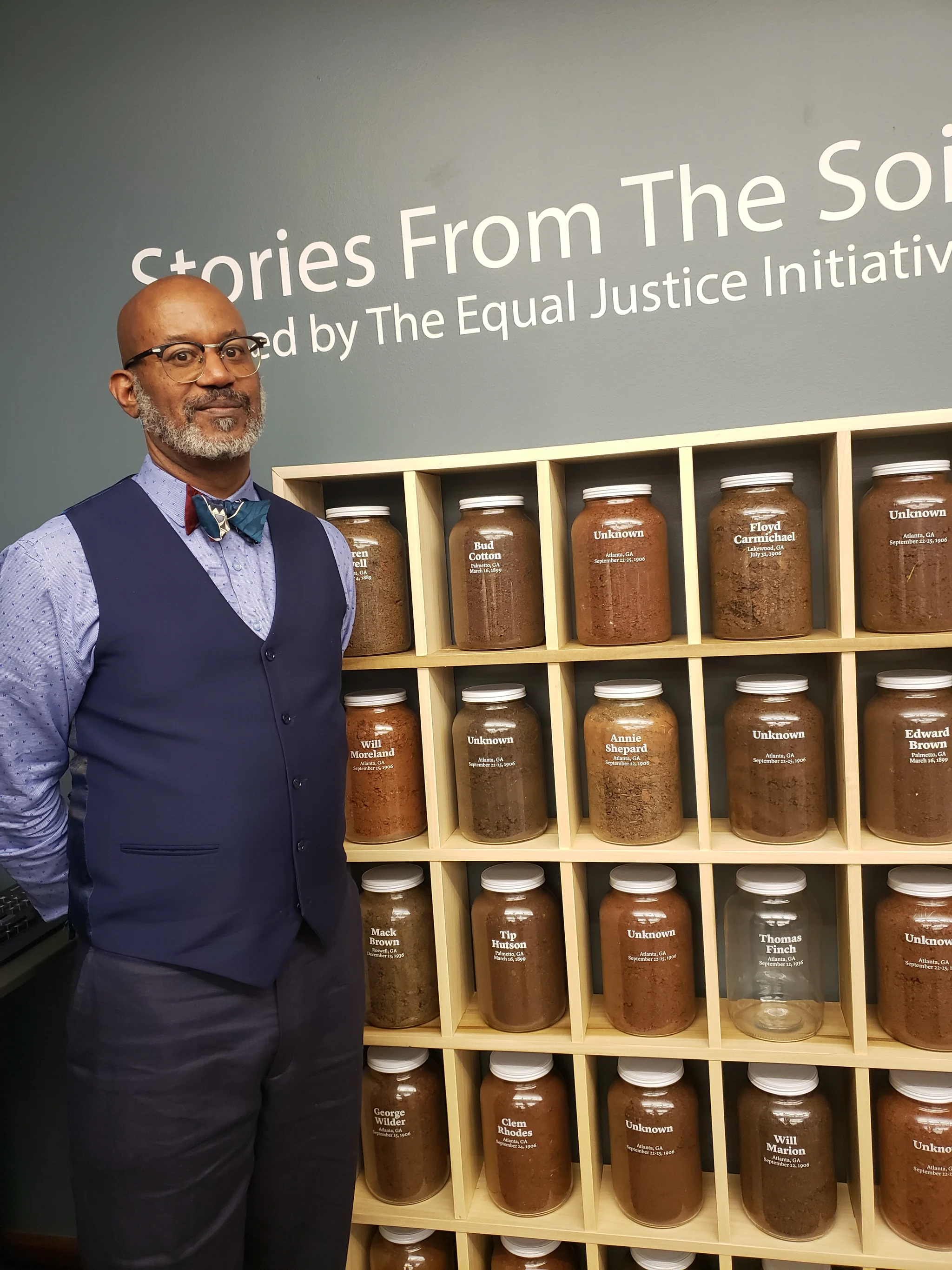 David beside a display of jars of soil beneath the words Stories From The Soil