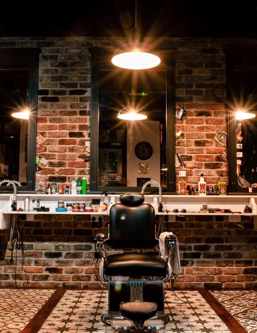 An empty barbershop with chairs, mirrors and warm hanging lights.